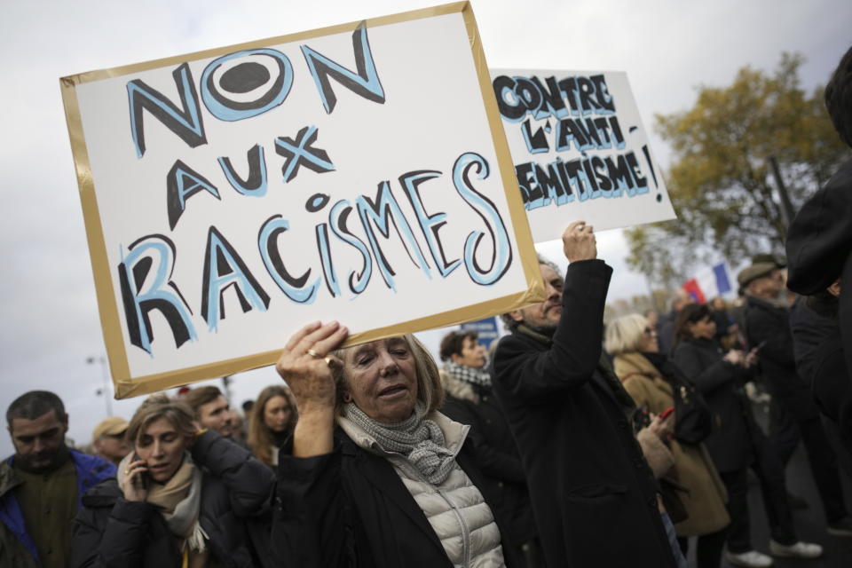 FILE - A woman carries a placard reading " no to racism" during a march against antisemitism in Paris, France, on Nov. 12, 2023. Antisemitism is spiking across Europe after Hamas' Oct. 7 massacre and Israel's bombardment of Gaza, worrying Jews from London to Geneva and Berlin. (AP Photo/Christophe Ena, File)