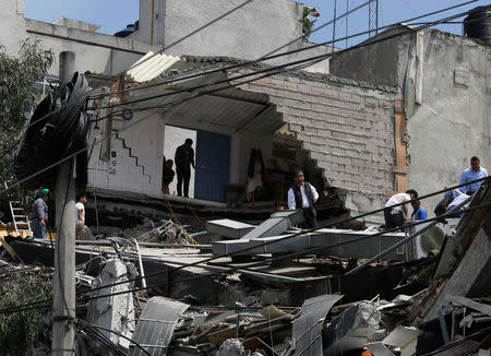 People work at a collapsed building after an earthquake in Mexico City, Mexico September 19, 2017. REUTERS/Claudia Daut