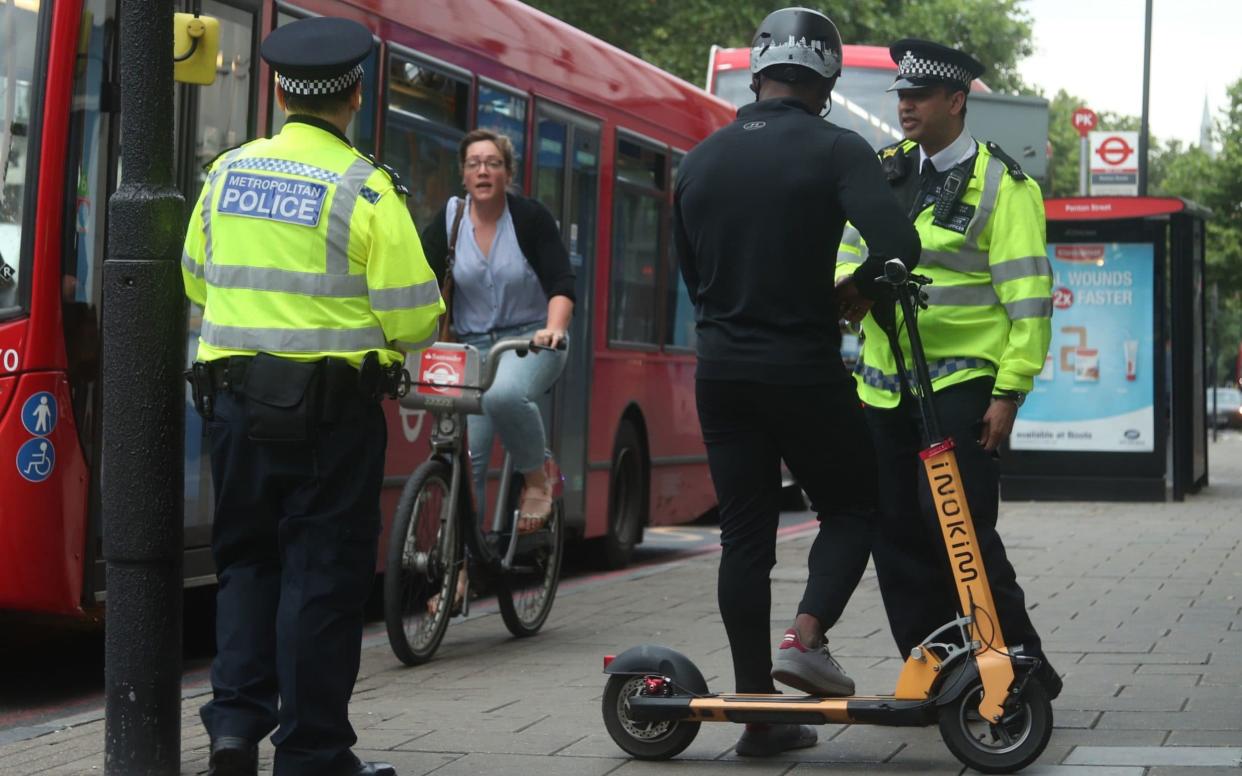 Metropolitan Police officers in Islington, London, talk to people riding e-scooters - PA