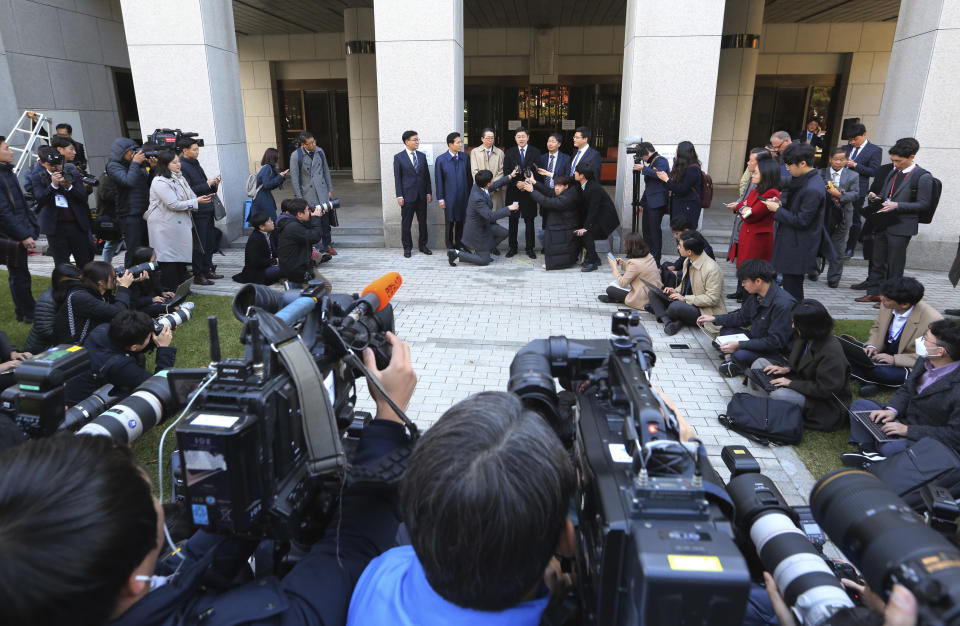 Oh Seung-hun, top center, speaks to the media after a court's verdict to overturn his conviction on refusing to do mandatory military service, at the Supreme Court in Seoul, South Korea, Thursday, Nov. 1, 2018. In a landmark verdict, South Korea's top court on Thursday ruled that people can legally reject mandatory military service on conscientious or religious grounds and must not be punished. (AP Photo/Ahn Young-joon)