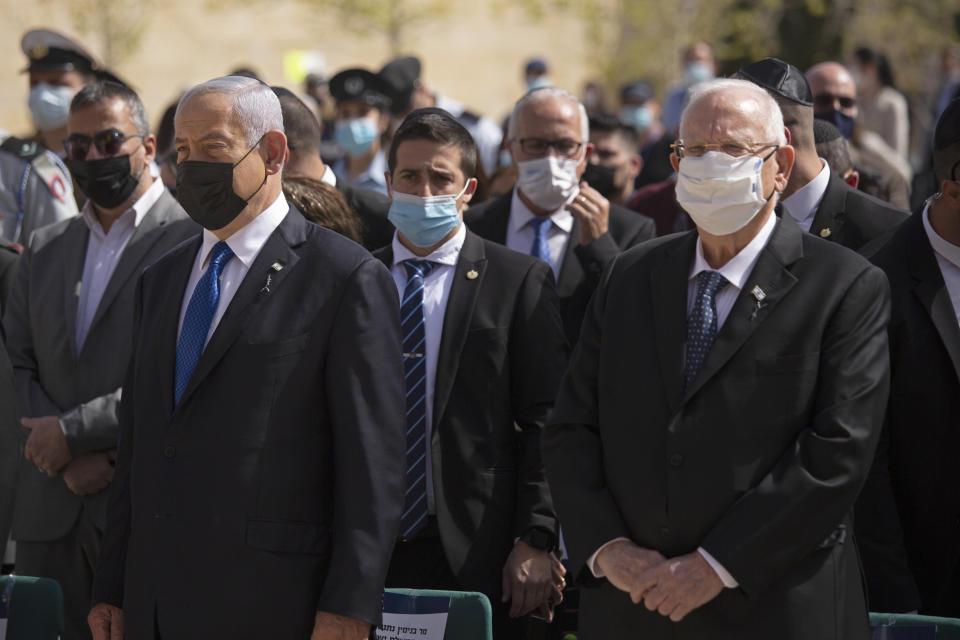 Israeli Prime Minister Benjamin Netanyahu, left, stands next to President Revin Rivlin as they attend a ceremony marking the annual Holocaust Remembrance Day, at Yad Vashem Holocaust Memorial in Jerusalem, Thursday, April 8, 2021. (AP Photo/Maya Alleruzzo, Pool)