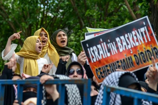 Protesters in the southeastern Turkish city of Diyarbakir hold a placard reading "hell is the capital of Israel" at a demonstration slamming the bloodshed along the Gaza border