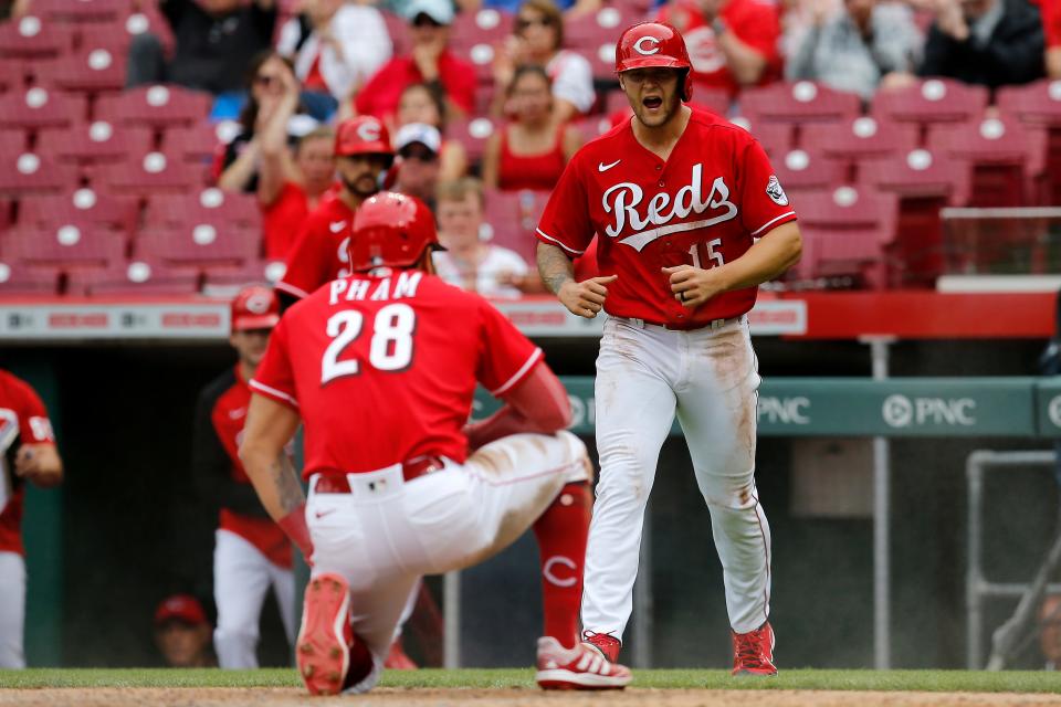 Cincinnati Reds center fielder Nick Senzel (15) cheers on designated hitter Tommy Pham (28) after he crosses the plate on an RBI single off the bat of Kyle Famrer in the sixth inning of the MLB National League game between the Cincinnati Reds and the Chicago Cubs at Great American Ball Park in downtown Cincinnati on Thursday, May 26, 2022. Following a 59 minute delay, the Reds won 20-5 in the series finale. 