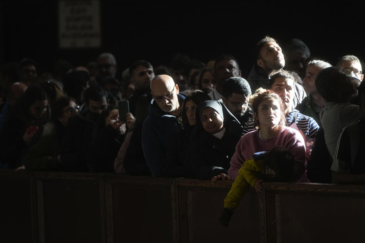 People queue inside St. Peter's Basilica at The Vatican, Wednesday, Jan. 4, 2023. For a third day, lines of people wanting to honor Pope Emeritus Benedict XVI 's service to the Catholic church snaked around St. Peter's Square on Wednesday to view the late retired pontiff's body. (AP Photo/Gregorio Borgia)