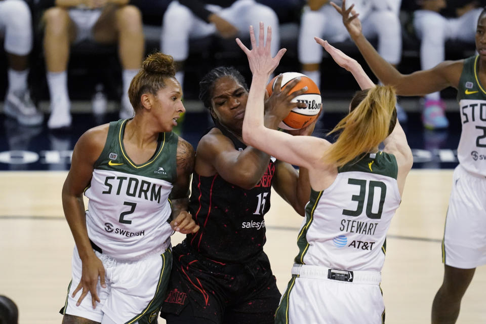 Indiana Fever's Teaira McCowan (15) works between Seattle Storm's Mercedes Russell (2) and Breanna Stewart (30) during the first half of a WNBA basketball game Thursday, June 17, 2021, in Indianapolis. (AP Photo/Darron Cummings)