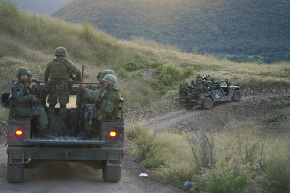 Soldiers patrol near the hamlet Plaza Vieja in the Michoacan state of Mexico, Thursday, Oct. 28, 2021. The Mexican army has largely stopped fighting drug cartels here, instead ordering soldiers to guard the dividing lines between gang territories so they won’t invade each other’s turf — and turn a blind eye to the cartels’ illegal activities just a few hundred yards away. (AP Photo/Eduardo Verdugo)