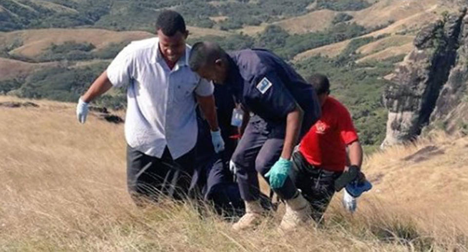 police carry item up mountain in Nausori Highlands in Nadi, Western Fiji, were bodies were found.