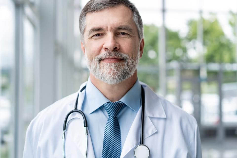 Confident smiling doctor posing in the hospital.