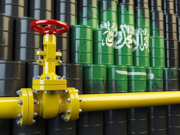 An oil pipeline valve in front of the Saudi Arabia flag.