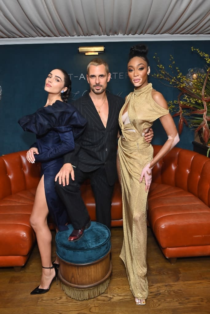 Olivia Culpo strikes a pose with fashion photographer Greg Swales and fellow model Winnie Harlow at the pre-Oscars get-together in Hollywood. - Credit: Getty