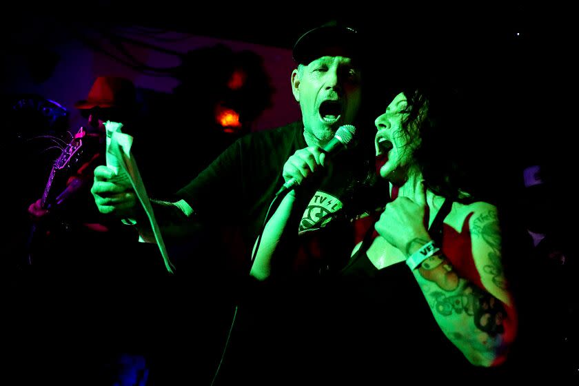 HUNTINGTON BEACH, CA - JUNE 13: Farell and Melinda sing "Los Angeles" by the band X at Punk Rock Karaoke at Gallagher's Pub HB on Sunday, June 13, 2021 in Huntington Beach, CA. Since 1996 Punk Rock Karaoke band members play live music while aficionados karaoke to selected songs. Punk Rock Karaoke band members; Greg Hetson (Bad Religion, Circle Jerks): Guitar-Vocals, Stan Lee (The Dickies): Guitar, Randy Bradbury (Pennywise): Bass-Vocals and Darrin Pfeiffer (Goldfinger) Drums-Vocals. (Gary Coronado / Los Angeles Times)