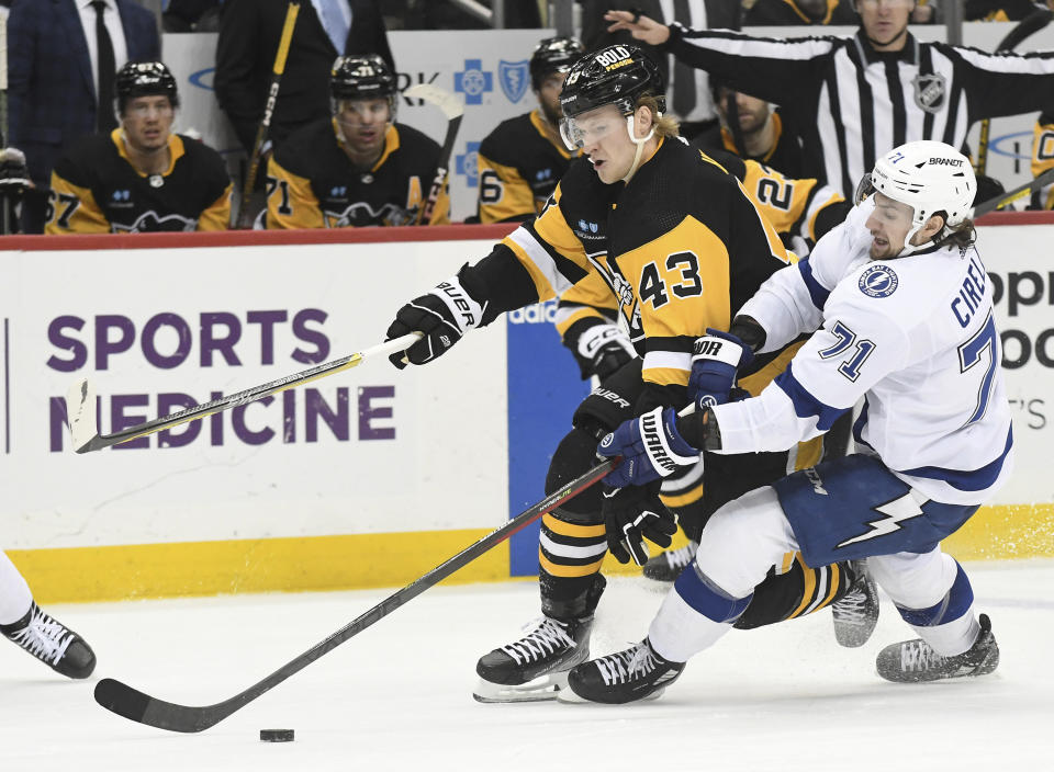 Pittsburgh Penguins left wing Danton Heinen (43) and Tampa Bay Lightning center Anthony Cirelli (71) battle for the puck during the second period of an NHL hockey game, Sunday, Feb. 26, 2023, in Pittsburgh. (AP Photo/Philip G. Pavely)