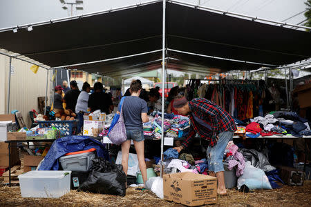 Residents of the Leilani Estates and Lanipuna Gardens subdivisions, who were evacuated from their homes due to eruptions of the Kilauea Volcano, pick up supplies at a community donation center in Pahoa. REUTERS/Terray Sylvester