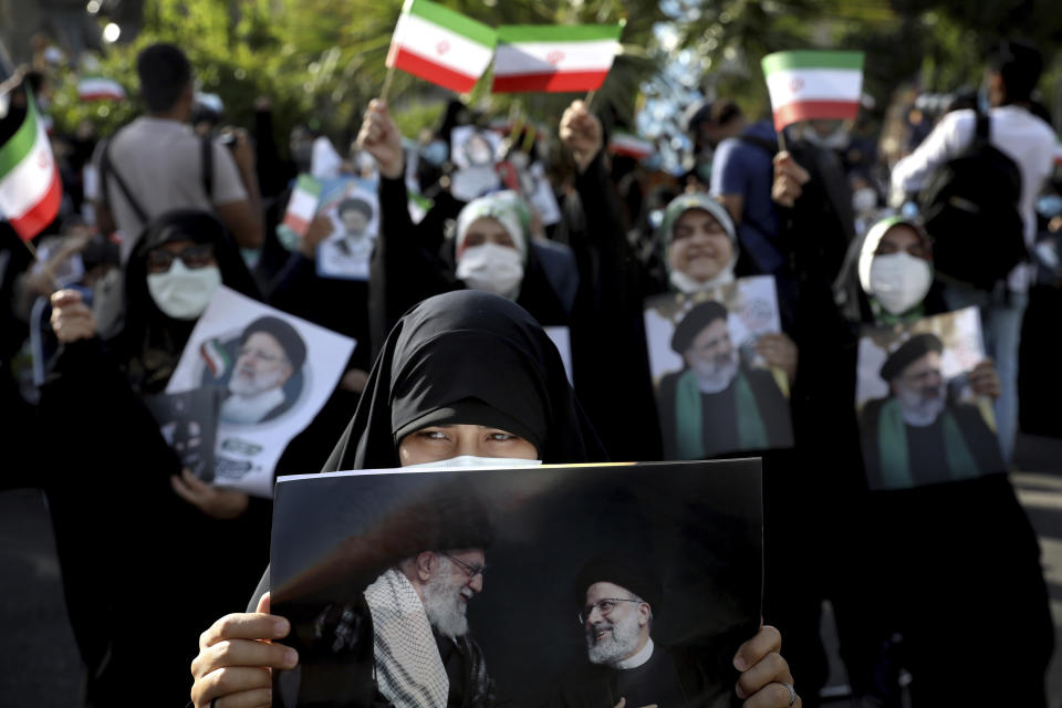 Supporters of presidential candidate Ebrahim Raisi hold signs during a rally in Tehran, Iran, Wednesday, June 16, 2021. Iran's clerical vetting committee has allowed just seven candidates for the Friday, June 18, ballot, nixing prominent reformists and key allies of President Hassan Rouhani. The presumed front-runner has become Ebrahim Raisi, the country's hard-line judiciary chief who is closely aligned with Supreme Leader Ayatollah Ali Khamenei. (AP Photo/Ebrahim Noroozi)