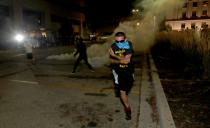 Aug 23, 2020; Kenosha, WI, USA; A protestor runs after being hit by a rubber bullet outside the Kenosha Police Department in Kenosha on Sunday, Aug. 23, 2020. Kenosha police shot a man Sunday evening, setting off unrest in the city after a video appeared to show the officer firing several shots at close range into the man's back Mandatory Credit: Mike De Sisti/Milwaukee Journal Sentinel via USA TODAY NETWORK/Sipa USA