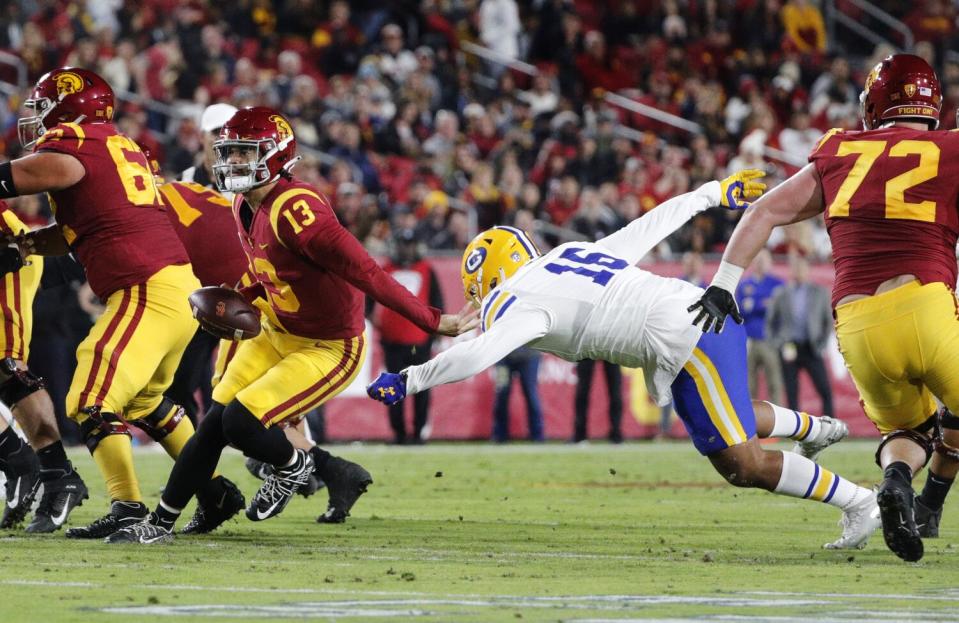 USC quarterback Caleb Williams (13) evades a sack attempt by California linebacker Henry Ikahihifo (16).