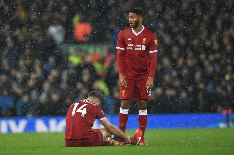 Liverpool's Joe Gomez (R) stands next to injured teammate Jordan Henderson during their English Premier League match against Everton, at Anfield in Liverpool, on December 10, 2017