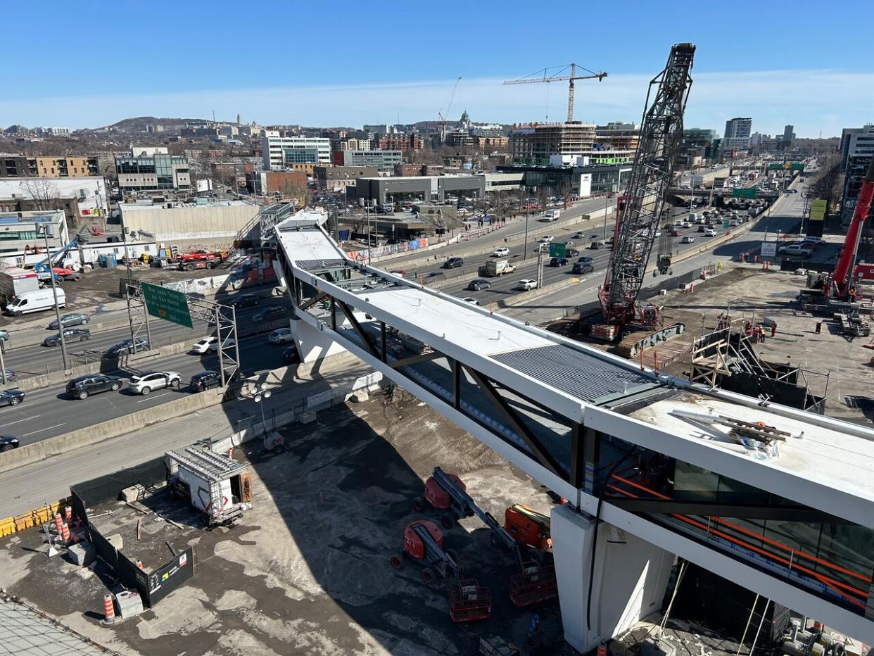 A 200-metre pedestrian skywalk was installed over the Décarie Expressway, connecting Montreal's de la Savane Metro station with the future Royalmount mega-mall complex in the Town of Mount Royal (TMR) at the junction of Highways 15 and 40. (Steve Rukavina/CBC - image credit)