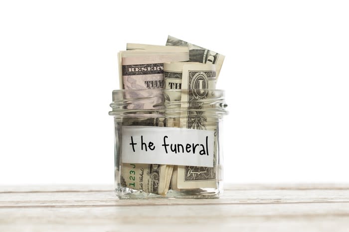 Jar that says the funeral filled with rolled-up dollar bills.