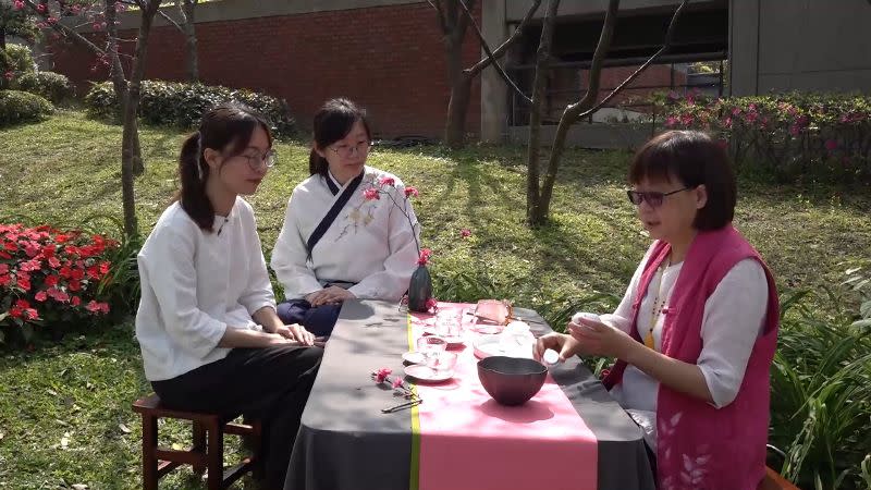 大葉大學老師帶領學生在櫻花樹下擺設茶席，邊賞花邊品茗。