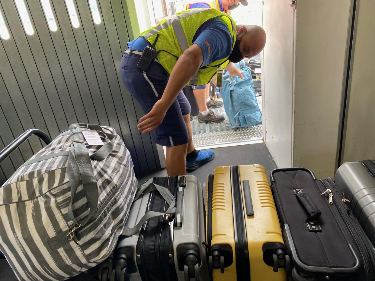 Bagage handler with last minute checked suitcases, Palm Beach Gardens International Airport, Florida. (Photo by: Lindsey Nicholson/Universal Images Group via Getty Images)