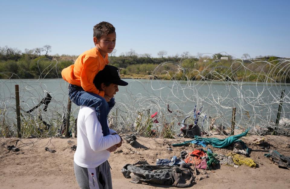 Angelica Reyes walks along the Rio Grande with Fabian Los Diaz, 6, to surrender to Border Patrol agents last month after entering Texas at Eagle Pass with a group of fellow Venezuelan migrants. On Thursday, former President Donald Trump will visit Eagle Pass while President Joe Biden visits Brownsville.
