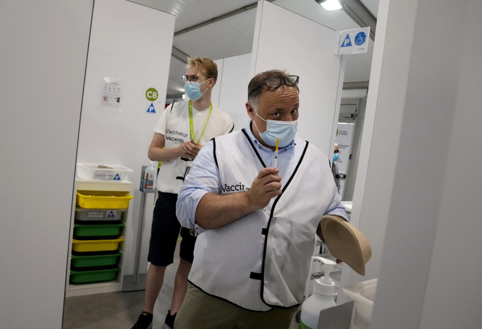 Belgium's chief virologist Mark Van Ranst, right, prepares to administer the Pfizer COVID-19 vaccine at the Vaccine Village in Antwerp, Belgium on Wednesday, June 30, 2021. (AP Photo/Virginia Mayo)