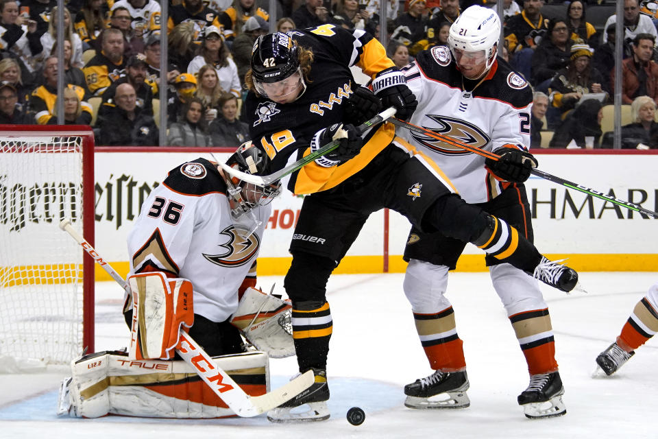 Pittsburgh Penguins' Kasperi Kapanen (42) can't get his stick on a rebound off Anaheim Ducks goaltender John Gibson (36) with Isac Lundestrom (21) defending during the second period of an NHL hockey game in Pittsburgh, Saturday, Dec. 11, 2021. (AP Photo/Gene J. Puskar)