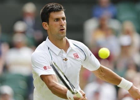 Novak Djokovic of Serbia hits a shot during his match against Bernard Tomic of Australia at the Wimbledon Tennis Championships in London, July 3, 2015. REUTERS/Suzanne Plunkett