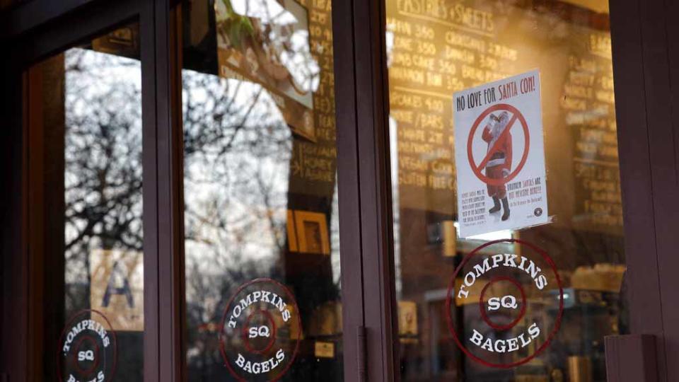 A sign posted by a bagel shop in NYC informs SantaCon participants they are “not welcome” inside the establishment on Dec. 9, 2015. (AP Photo/Mary Altaffer)