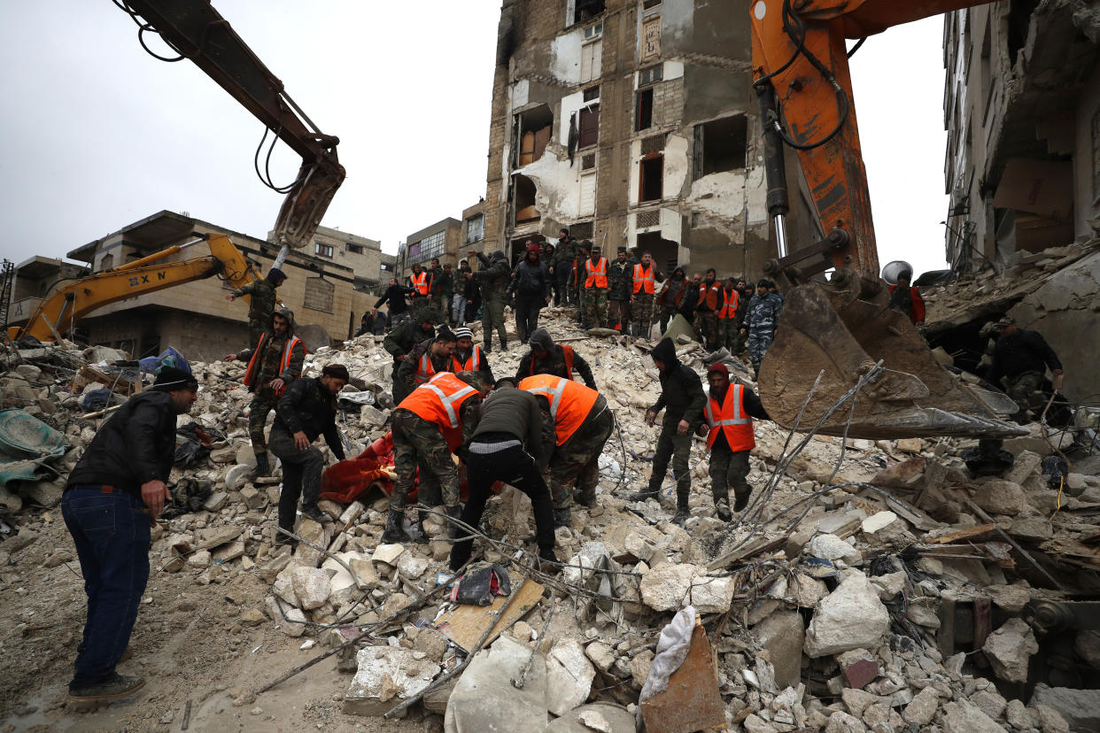 Civil defense workers and security forces search through the wreckage of collapsed buildings in Hama, Syria, Monday, Feb. 6, 2023. A powerful earthquake has caused significant damage in southeast Turkey and Syria and many casualties are feared. Damage was reported across several Turkish provinces, and rescue teams were being sent from around the country. (AP Photo/Omar Sanadiki)