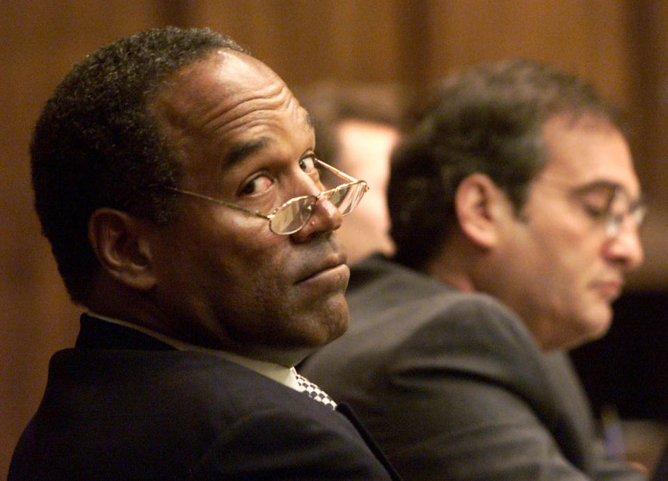 <p>O.J. Simpson looks back into the courtroom gallery as co-defense council Lee Cohn (R) watches during the fourth day of jury selection in his “road rage” trial in Miami, Fla., on Oct. 12, 2001. Simpson is on trial for allegedly attacking a Miami motorist in Dec. of 2000. If found guilty, Simpson faces up to 16 years in prison. (Photo: Pool/Wilfredo Lee/Reuters) </p>