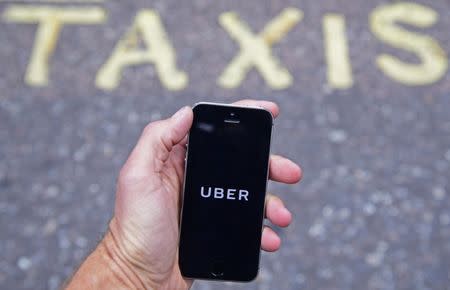 A photo illustration shows the Uber app logo displayed on a mobile telephone, as it is held up for a posed photograph in central London, Britain October 28, 2016. REUTERS/Toby Melville/Illustration