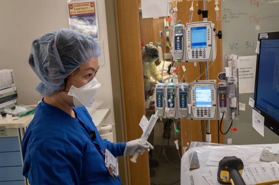 STAMFORD, CONNECTICUT - APRIL 24: (EDITORIAL USE ONLY) A nurse wearing an N95 mask works as intravenous therapy (IV) equipment hangs outside a COVID-19 patient's door in a Stamford Hospital intensive care unit (ICU), on April 24, 2020 in Stamford, Connecticut. Stamford Hospital, like many across the US, opened additional ICUs to deal the the vast number of people suffering in the coronavirus pandemic. Stamford, with it's close proximity to New York City, has the highest number of coronavirus (COVID-19) patients in Connecticut. (Photo by John Moore/Getty Images)