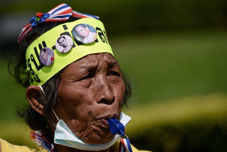 A Thai anti-government protester with badges carrying pictures of King Bhumibol Adulyadej outside the Army Club in Bangkok on January 28, 2014