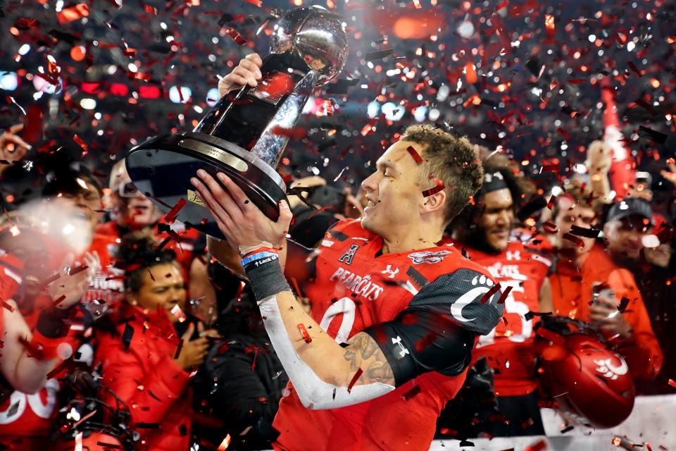 Cincinnati quarterback Desmond Ridder (9) raises the American Athletic Conference championship trophy after the Bearcats defeated Houston 35-20 on Dec. 4 in Cincinnati.