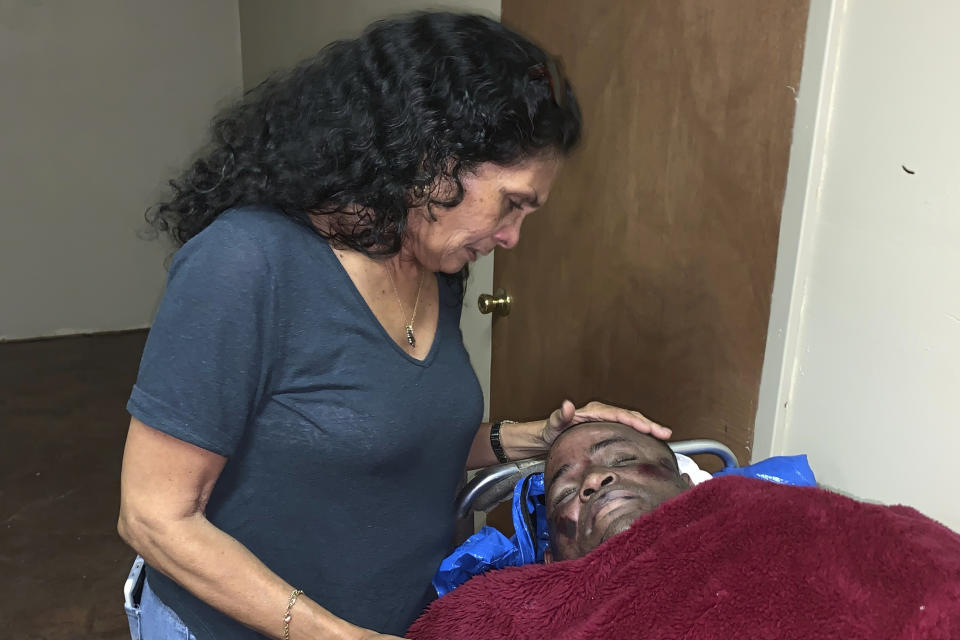 FILE - EDS NOTE: GRAPHIC CONTENT - In this photo provided by Alana Wilson, Mona Hardin looks over the body of her son, Ronald Greene in Rayville, La., on May 13, 2019. "I've been wandering around in a cloud of confusion just wondering: What does it take for the state of Louisiana to recognize the murder of a man? What does it take to get answers?" Hardin told Louisiana state lawmakers in a December 2021 hearing. (Alana Wilson via AP, File)