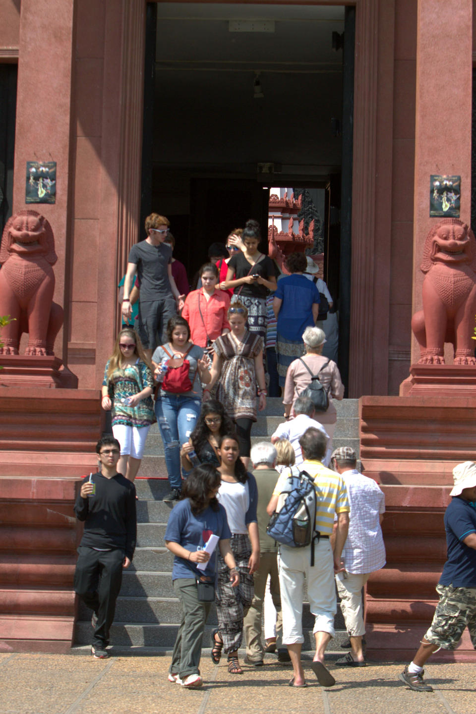 In this Wednesday, Feb. 27, 2013, foreign tourists walk through an entrance of a museum, in Phnom Penh, Cambodia. Phnom Penh's developing tourism sector also means that nearly every attraction has an entry fee, even if just a dollar or two. But in keeping with history, some sites cost nothing at all. (AP Photo/Heng Sinith)