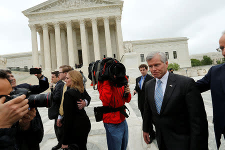 Former Virginia Governor Bob McDonnell is trailed by reporters as he departs after his appeal of his 2014 corruption conviction was heard at the U.S. Supreme Court in Washington, U.S. April 27, 2016. REUTERS/Jonathan Ernst