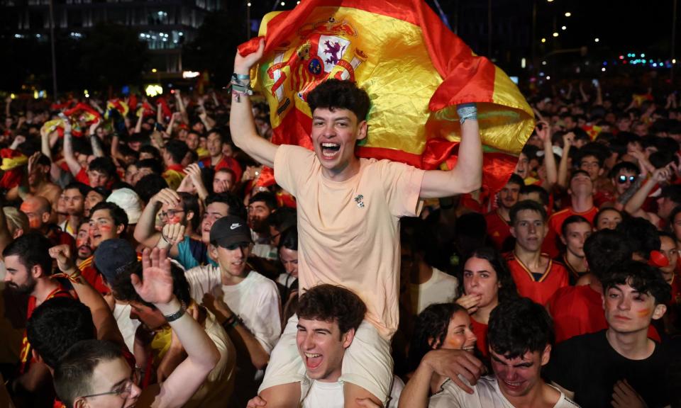 <span>Spain fans celebrate after the final whistle at the Plaza de Cibeles in Madrid.</span><span>Photograph: Isabel Infantes/Reuters</span>