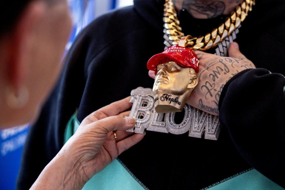 Rapper Forgiato Blow shows a person his Trump-themed jewelry at the Conservative Political Action Conference (CPAC) annual meeting in National Harbor, Maryland, U.S., February 22, 2024 (REUTERS)