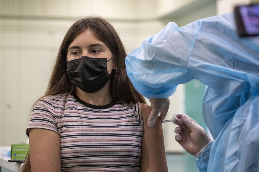 Eagle Rock, CA - August 30: A nurse gives a Pfizer-BioNTech vaccine shot to Gizelle Carrillo, 14, at Eagle Rock High School, as Los Angeles County Board of Supervisors Chair Hilda Solis, Interim Superintendent Megan K. Reilly, School Board members Kelly Gonez and Jackie Goldberg and special guests visit Los Angeles Unified School-based mobile vaccination clinics at Eagle Rock High School on Monday, Aug. 30, 2021 in Eagle Rock, CA. All employees in the Los Angeles Unified School District must be vaccinated against COVID-19 by Oct. 15, an order that puts it at the forefront of school systems across the country that are mandating strict coronavirus safety measures for employees and students. (Allen J. Schaben / Los Angeles Times)