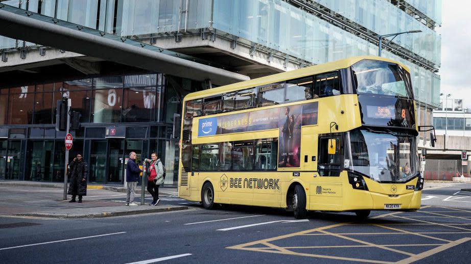 Yellow double decker 'Bee Network' branded bus in Manchester city centre