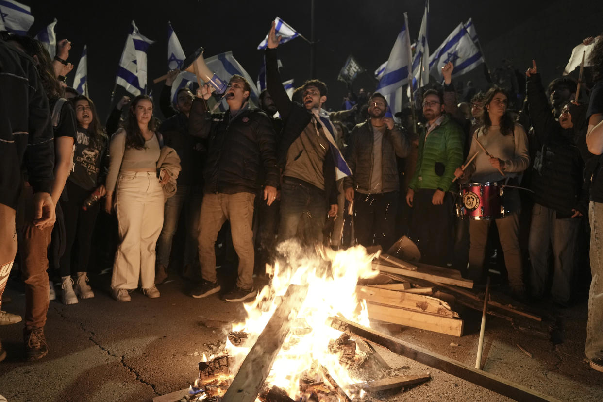 Israelis opposed to Prime Minister Benjamin Netanyahu's judicial overhaul plan protest outside of the Knesset, the country's parliament, after the Israeli leader fired his defense minister, in Jerusalem, Monday, March 27, 2023. Defense Minister Yoav Gallant had called on Netanyahu to freeze the plan, citing deep divisions in the country and turmoil in the military. (AP Photo/ Mahmoud Illean)