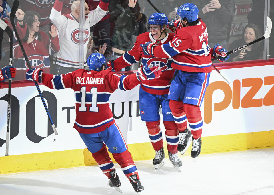 Montreal Canadiens' Kaiden Guhle, center, celebrates with teammates Brendan Gallagher (11) and Alex Newhook (15) after scoring against the Boston Bruins during overtime NHL hockey game action in Montreal, Saturday, Nov. 11, 2023. (Graham Hughes/The Canadian Press via AP)