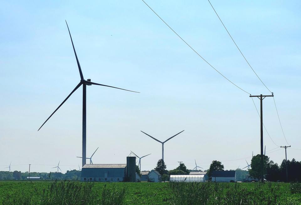 Wind turbines spin over agricultural land on Tuesday, May 30, 2023, in Huron Township.