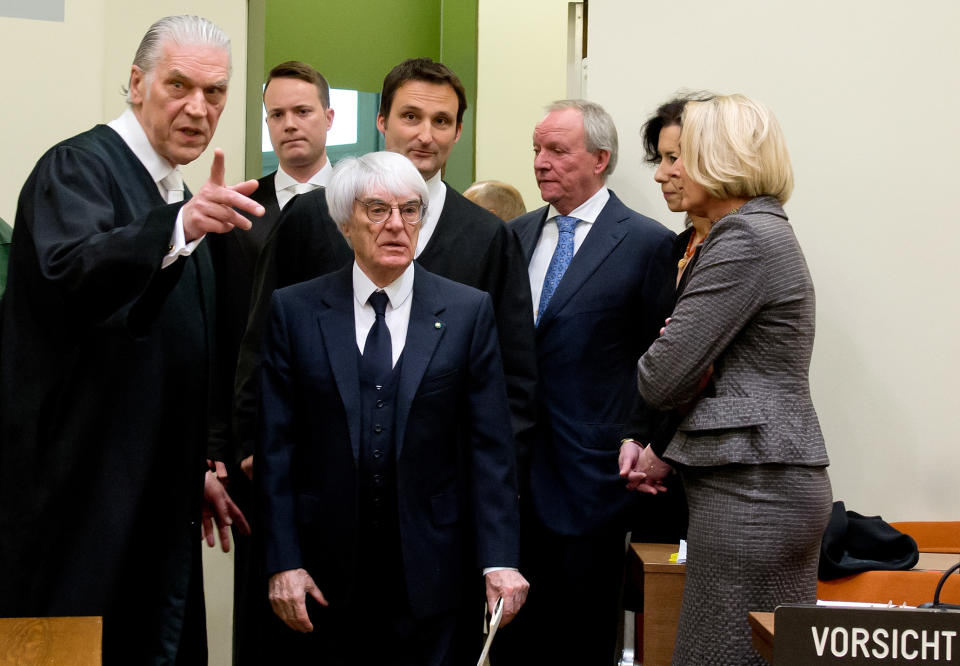 Formula One boss Bernie Ecclestone, center, arrives in the regional court in in Munich, Germany, Thursday, April 24, 2014. Ecclestone is charged with bribery and incitement to breach of trust "in an especially grave case" over a US$ 44 million payment to a German banker, that prosecutors allege was meant to facilitate the sale of the Formula One Group to a buyer of Ecclestone's liking. (AP Photo/Sven Hoppe, pool)