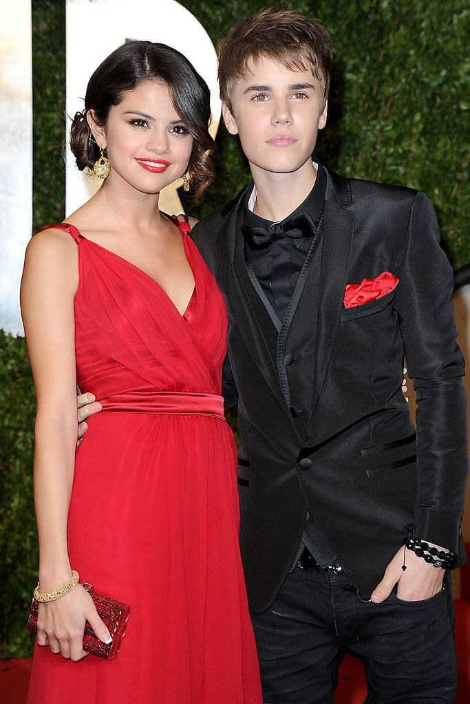 Selena in a sleeveless gown with Justin Bieber