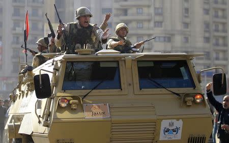 Army soldiers take their positions with their armoured personnel vehicle during clashes with supporters of Muslim Brotherhood and ousted Egyptian President Mohamed Mursi in the Cairo suburb of Matariya November 28, 2014. REUTERS/Mohamed Abd El Ghany