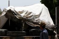 A worker walks past a truck loaded with the wreckage of the crashed plane, in Karachi,